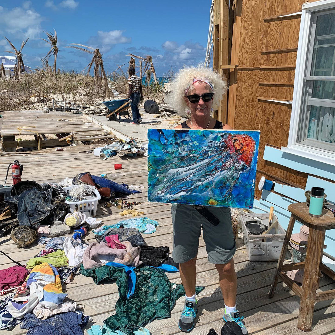 Montreal Artist Wendy Fee holding a piece of saved art after hurricane Dorion destroyed her home.